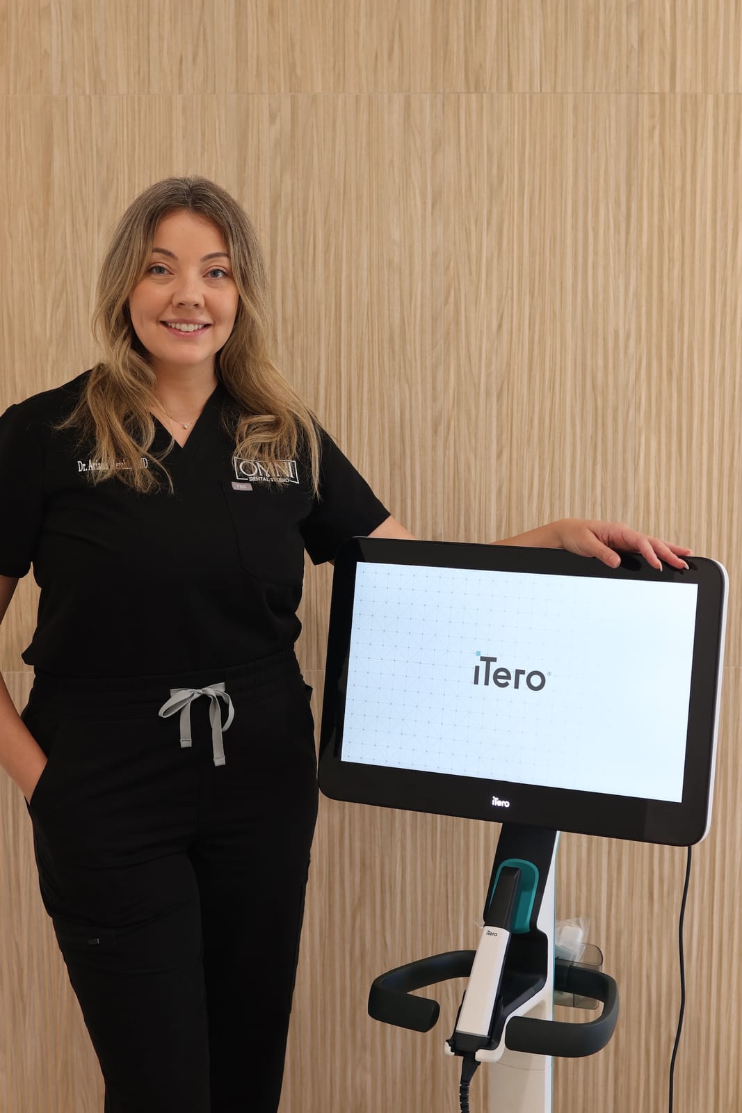 Dr. Ariana Merchi beside the iTero intraoral scanner at Omni Dental Studio